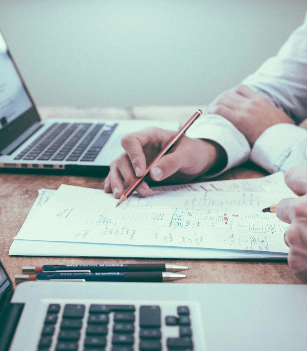 People reviewing documents and using laptops during a work meeting